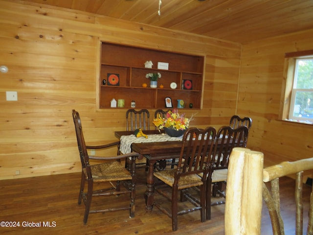 dining area with wood ceiling, built in shelves, wooden walls, and hardwood / wood-style floors