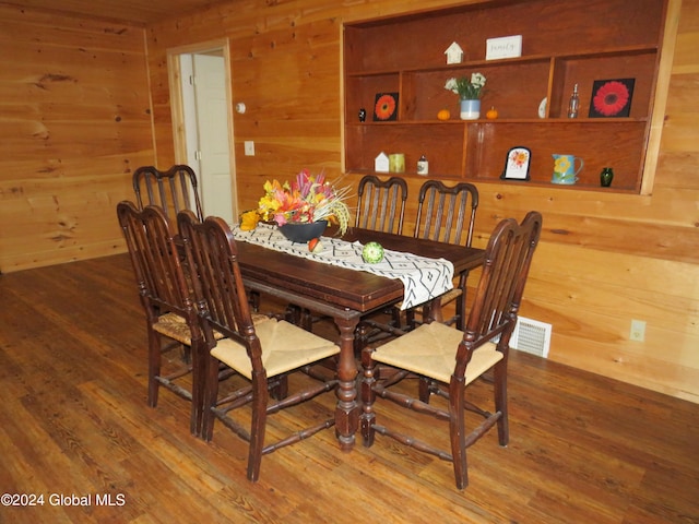 dining area featuring wood walls and hardwood / wood-style floors