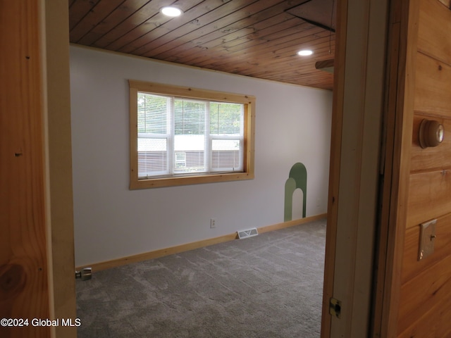 carpeted spare room with wooden ceiling