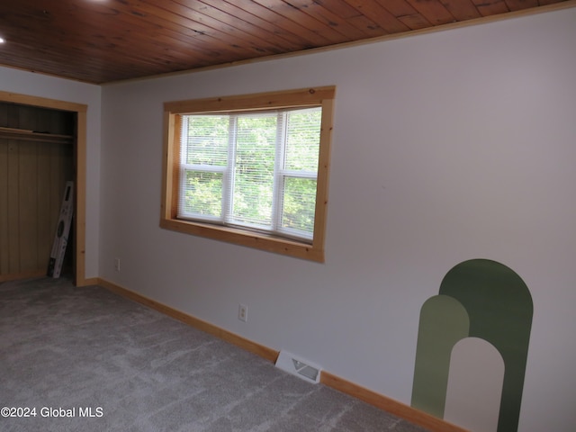 unfurnished bedroom featuring carpet and wooden ceiling