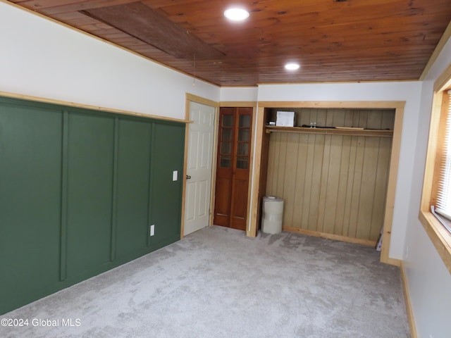 unfurnished bedroom with wooden ceiling and light carpet