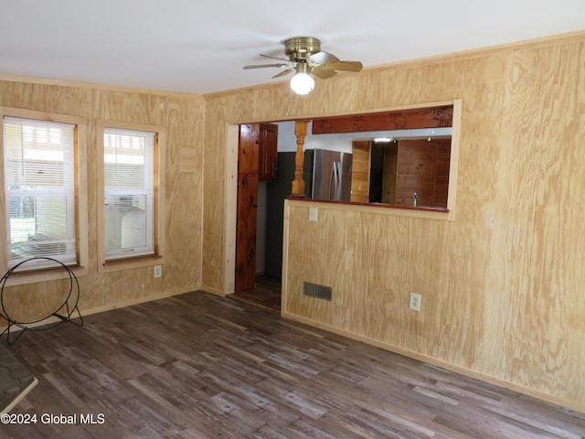 unfurnished room with ceiling fan, wooden walls, and dark hardwood / wood-style flooring