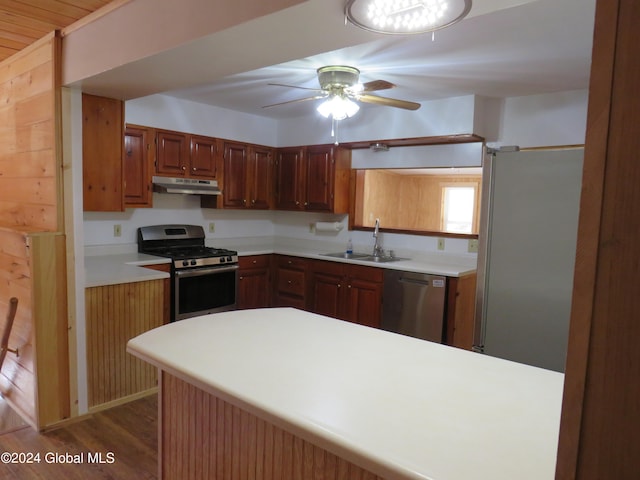 kitchen featuring dark wood-type flooring, sink, kitchen peninsula, stainless steel appliances, and ceiling fan