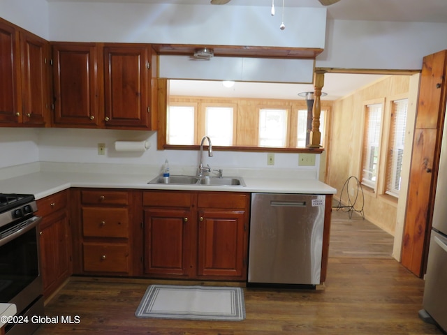 kitchen with appliances with stainless steel finishes, dark hardwood / wood-style floors, and sink