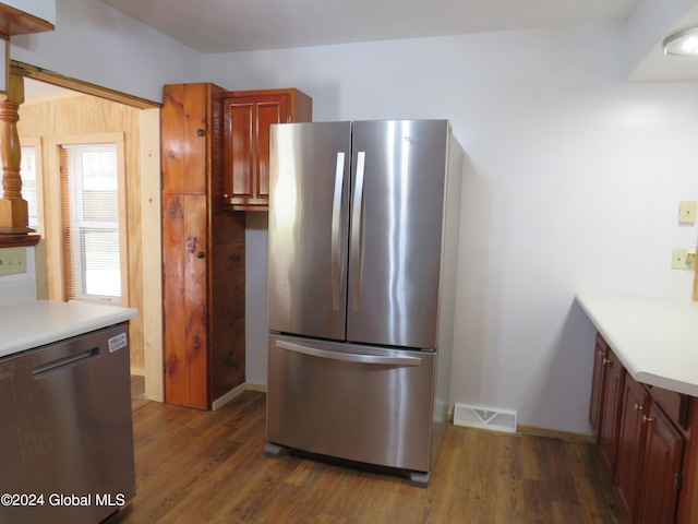 kitchen with appliances with stainless steel finishes and dark hardwood / wood-style floors