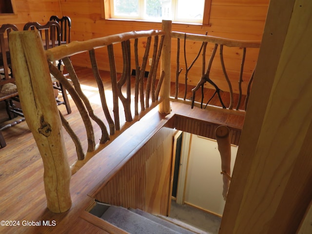 stairs with wooden walls and hardwood / wood-style floors