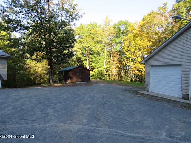 view of patio / terrace featuring a garage and a storage shed