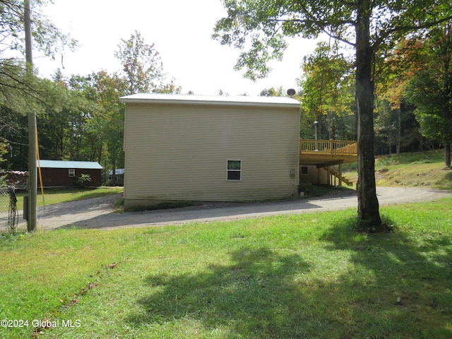 view of property exterior with a lawn and a deck