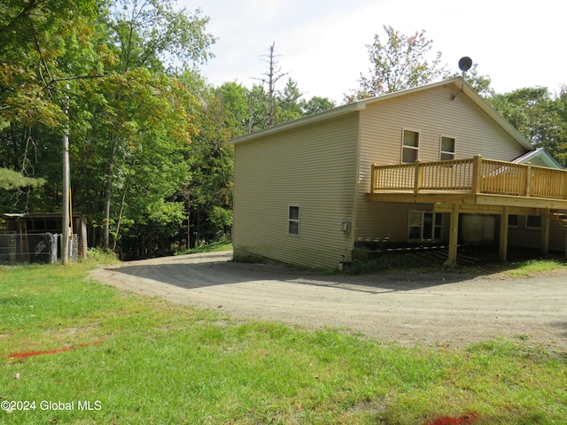 rear view of property featuring a lawn and a wooden deck