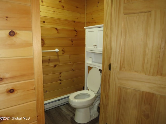 bathroom featuring a baseboard radiator, wooden walls, toilet, and hardwood / wood-style flooring