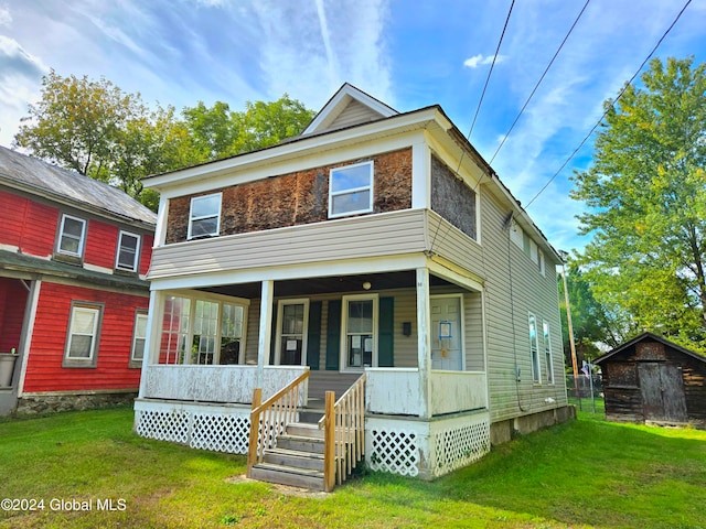 rear view of property with a porch and a lawn