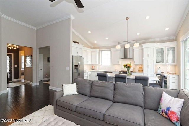 living room featuring ceiling fan with notable chandelier, ornamental molding, a healthy amount of sunlight, and dark hardwood / wood-style flooring