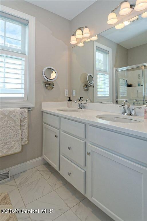 bathroom featuring vanity and a shower with shower door