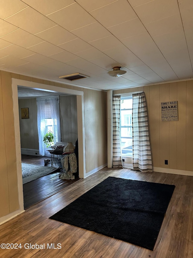 entryway with wood-type flooring, wood walls, and a wealth of natural light