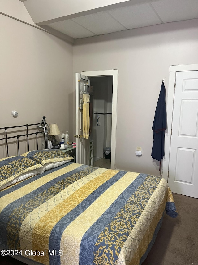 carpeted bedroom with a paneled ceiling