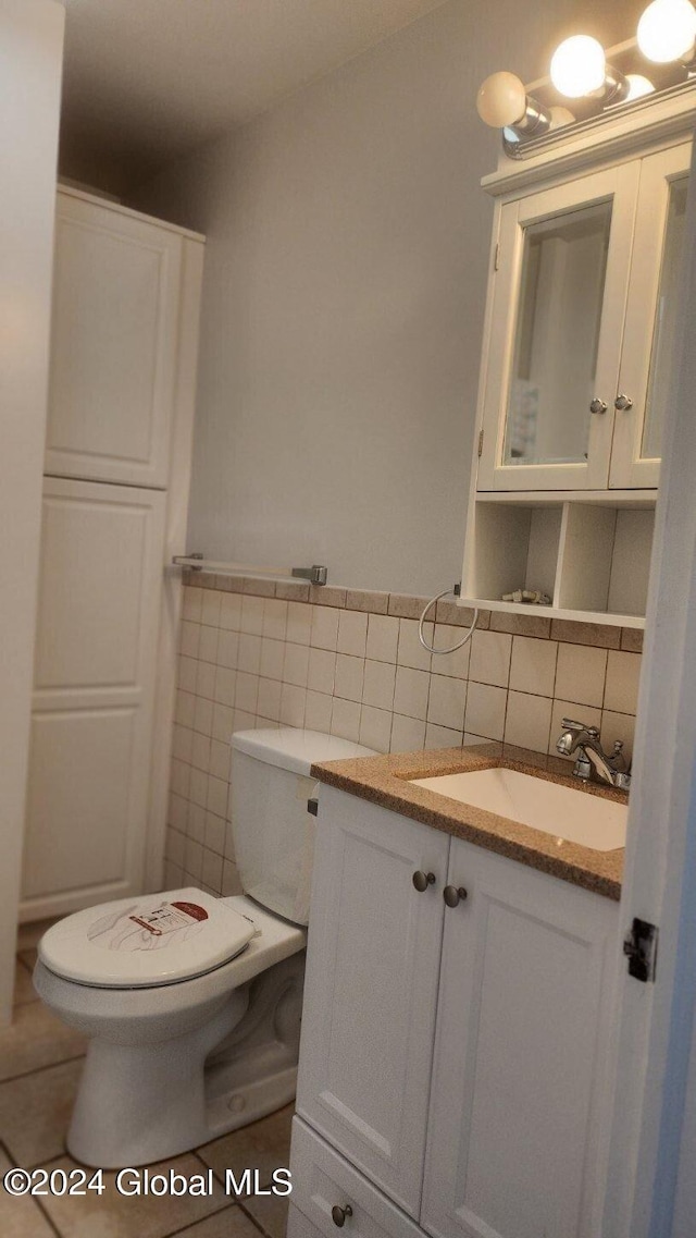 bathroom featuring tile walls, tile patterned flooring, decorative backsplash, vanity, and toilet