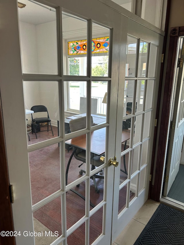 doorway to outside featuring light carpet and french doors