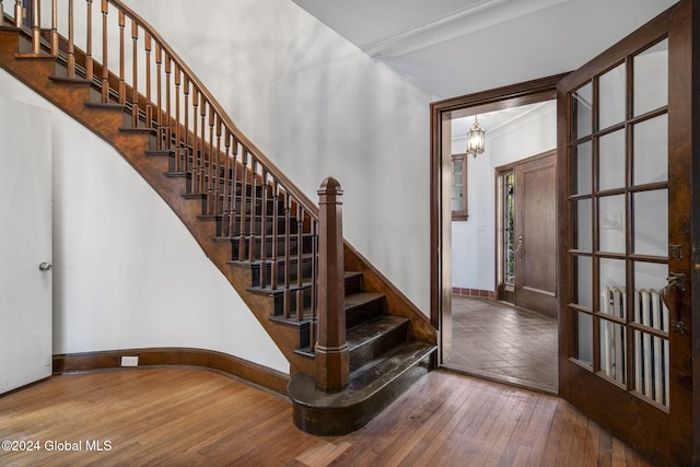 staircase featuring ornamental molding and hardwood / wood-style flooring