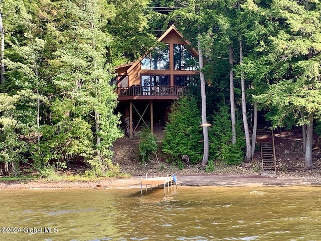 rear view of property featuring a deck with water view