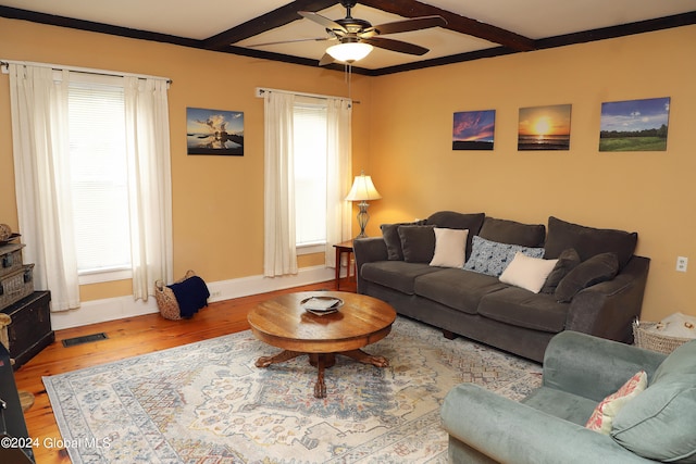 living room featuring wood-type flooring, ceiling fan, beamed ceiling, and a healthy amount of sunlight