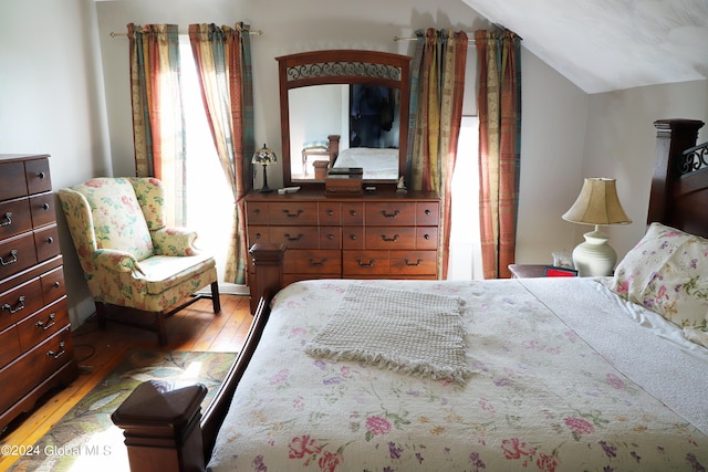 bedroom featuring wood-type flooring and vaulted ceiling