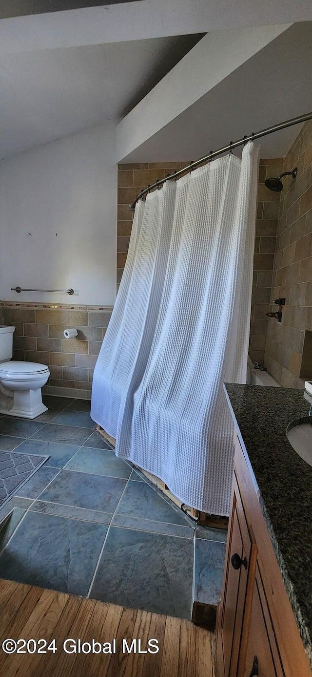 bathroom with hardwood / wood-style floors, vanity, toilet, and tile walls