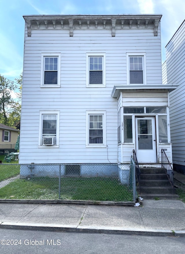 view of front of home with cooling unit and a front lawn