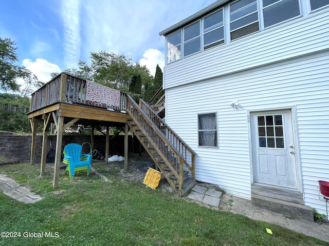 rear view of property featuring a wooden deck and a yard