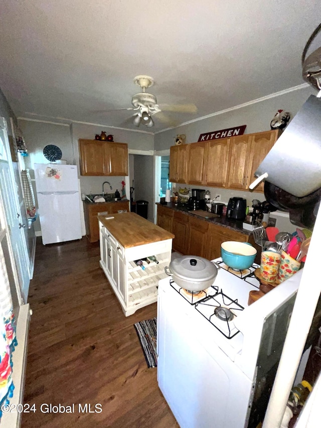 kitchen featuring ceiling fan, white refrigerator, ornamental molding, sink, and dark wood-type flooring