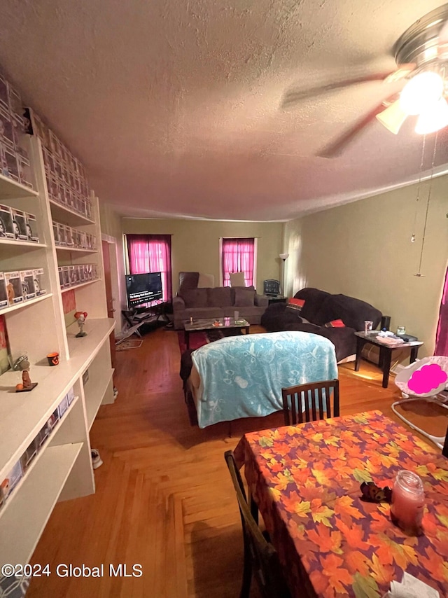 dining room featuring ceiling fan, a textured ceiling, and parquet flooring