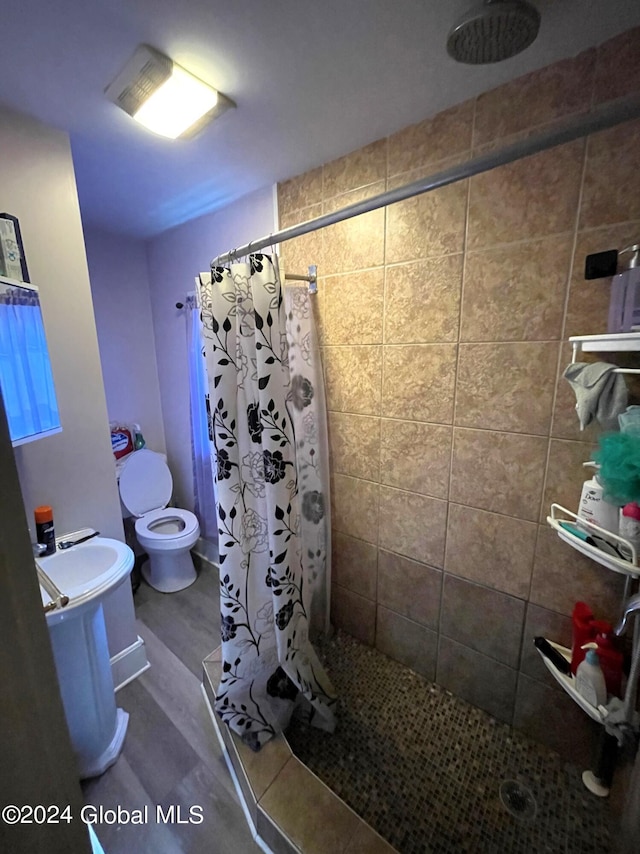 bathroom featuring toilet and curtained shower