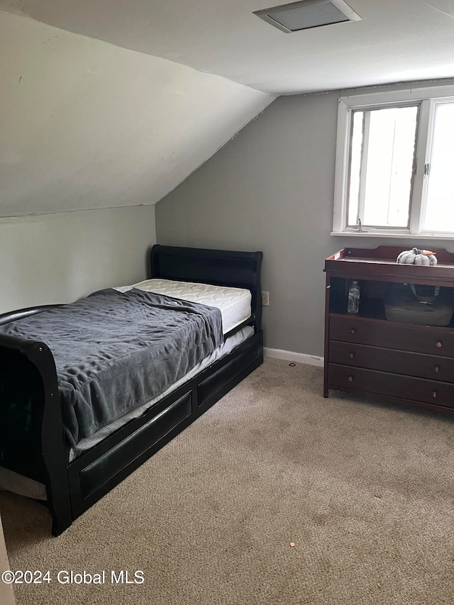 bedroom with lofted ceiling and light colored carpet