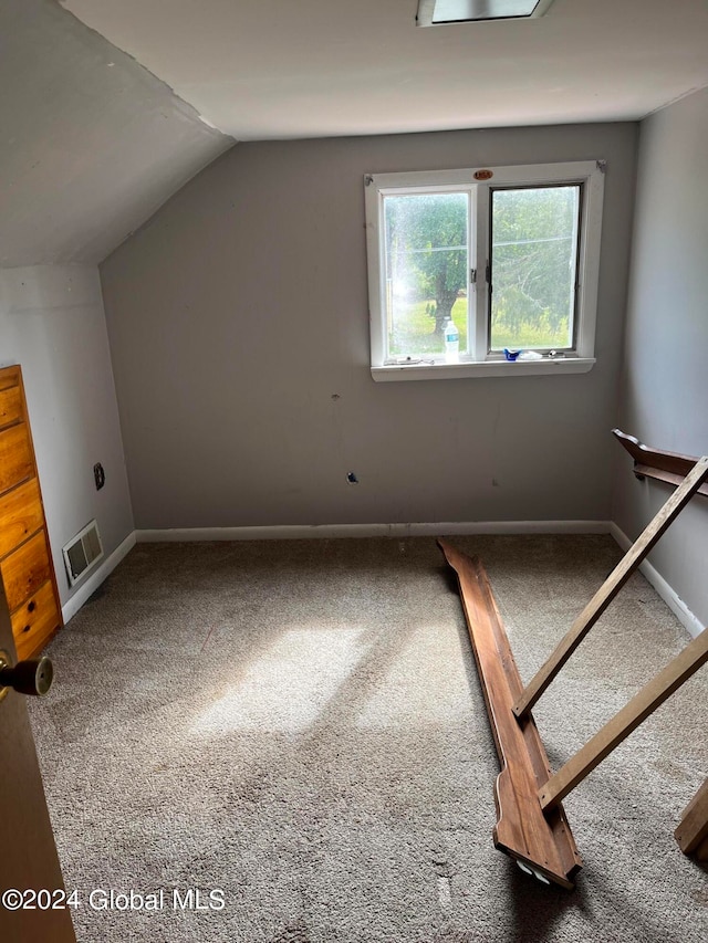 bonus room with vaulted ceiling and carpet flooring