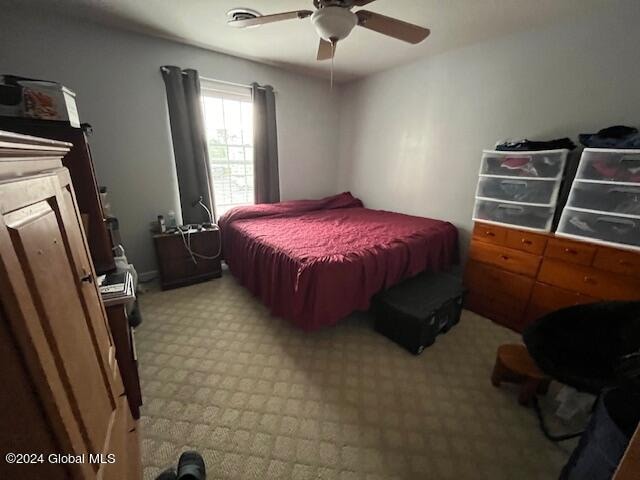 bedroom featuring light carpet and ceiling fan