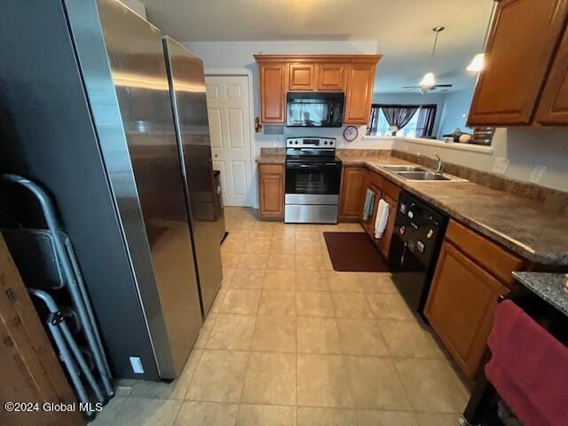 kitchen with hanging light fixtures, kitchen peninsula, black appliances, ceiling fan, and sink