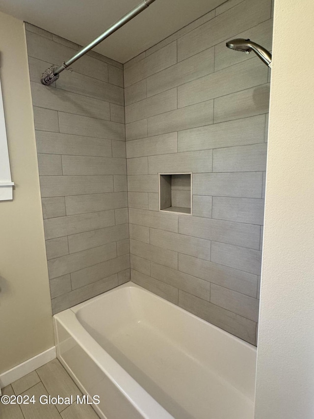 bathroom with tile patterned floors, baseboards, and shower / bathing tub combination