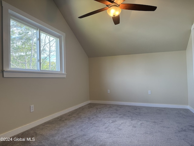 additional living space featuring carpet floors, vaulted ceiling, a ceiling fan, and a healthy amount of sunlight