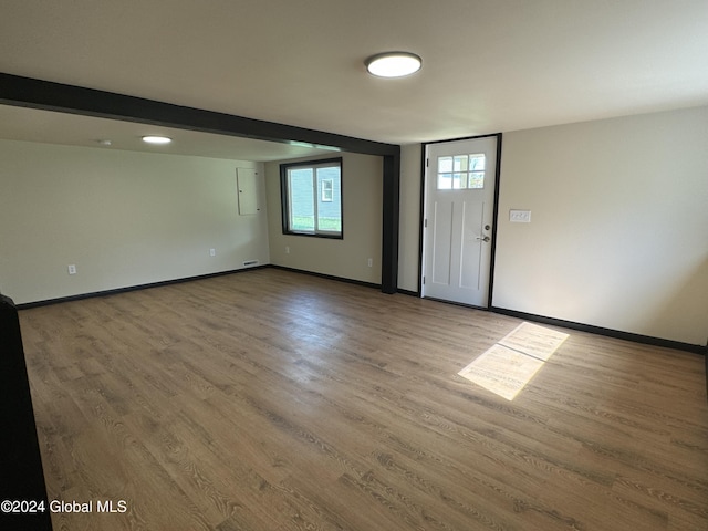 foyer featuring baseboards and wood finished floors