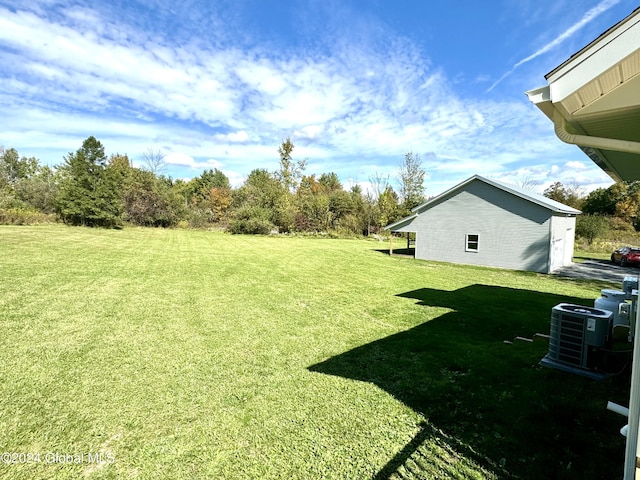 view of yard featuring central AC and an outdoor structure