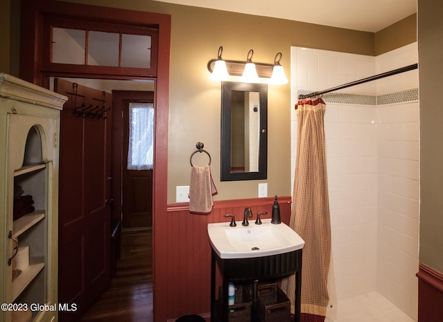 bathroom with walk in shower, vanity, and wood-type flooring