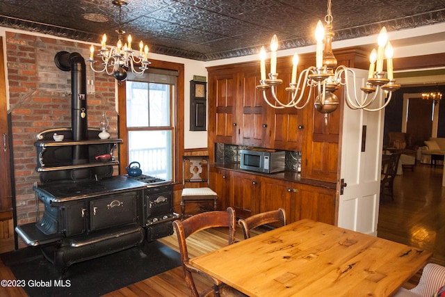 kitchen featuring hardwood / wood-style floors, a wood stove, and decorative light fixtures