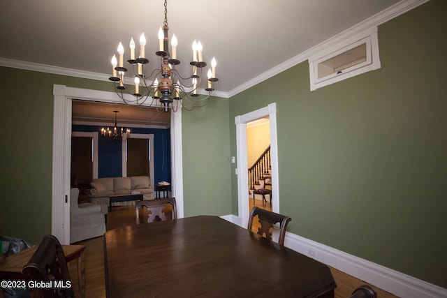 dining space featuring ornamental molding, hardwood / wood-style floors, and a notable chandelier