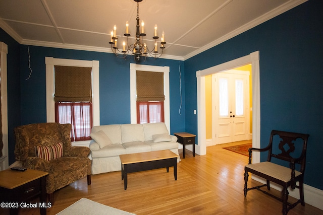 living room with crown molding, a chandelier, and hardwood / wood-style flooring