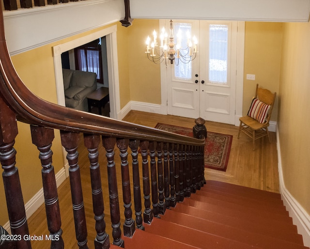 entrance foyer with an inviting chandelier and hardwood / wood-style floors