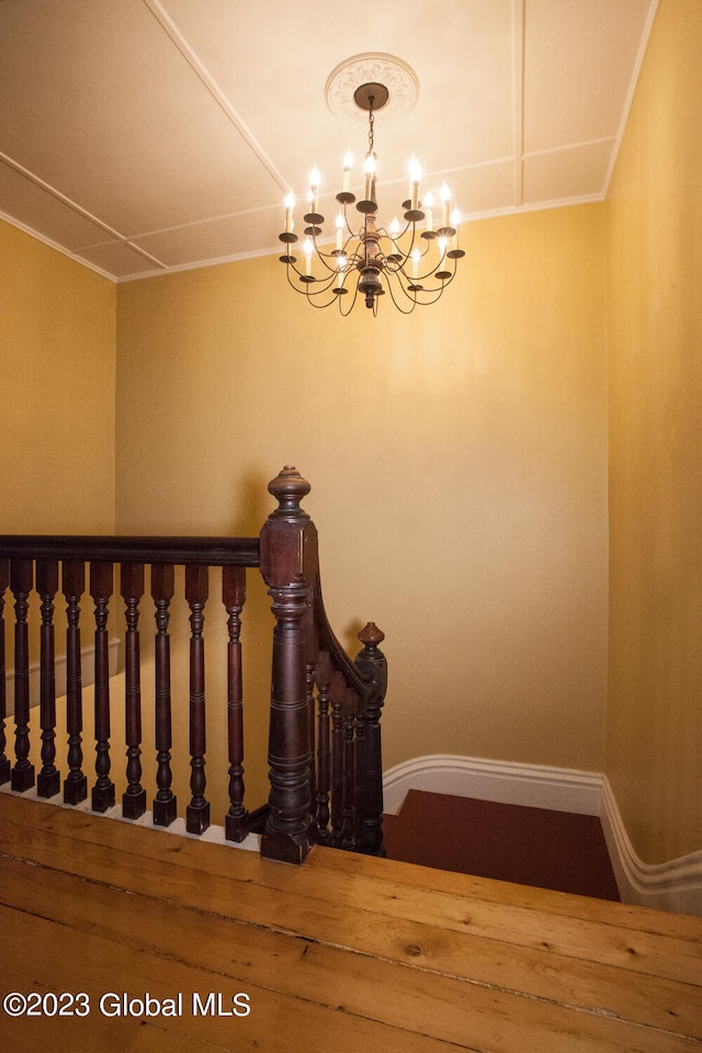 staircase with a notable chandelier