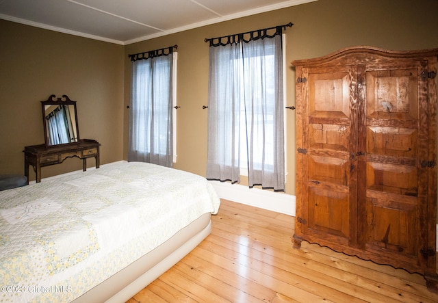 bedroom featuring light hardwood / wood-style flooring and ornamental molding