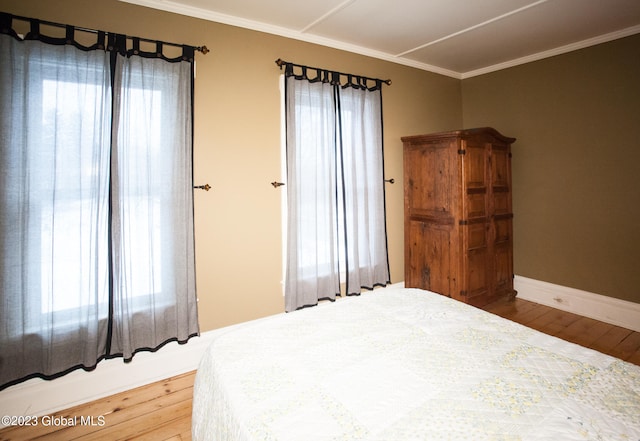 bedroom with wood-type flooring and ornamental molding