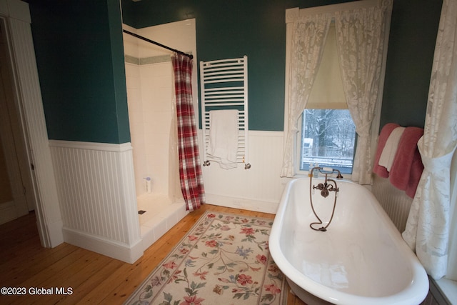 bathroom featuring wood-type flooring, radiator, and separate shower and tub