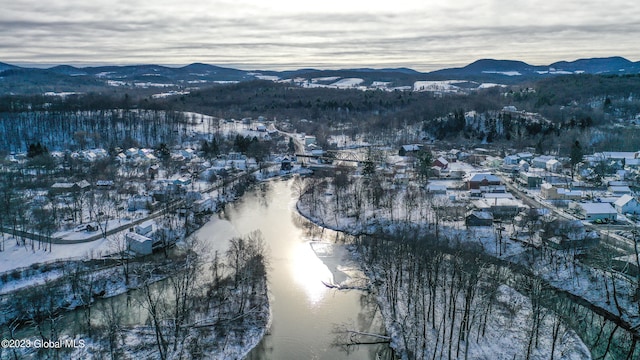 snowy aerial view with a water and mountain view