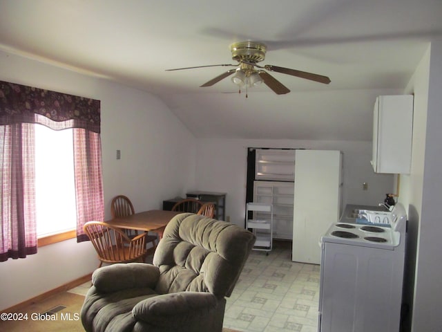 living area with visible vents, ceiling fan, light floors, and vaulted ceiling